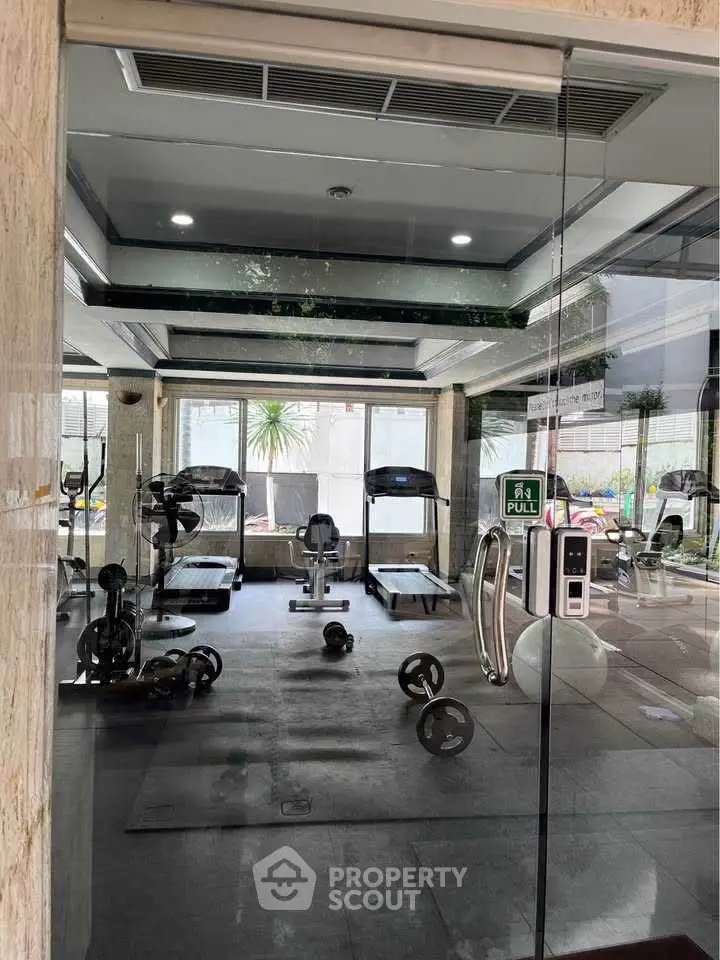 Modern gym with state-of-the-art equipment and large windows for natural light.