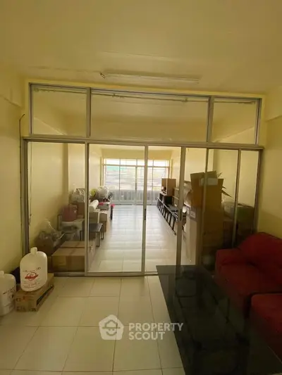 Spacious living room with glass partition and ample natural light, ideal for modern living.