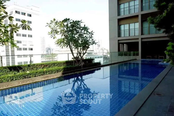 Luxurious rooftop pool with city views in modern high-rise building.