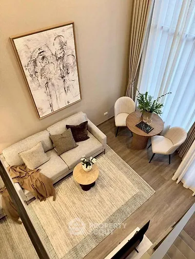 Elegant living room with high ceiling, modern decor, and cozy seating area.
