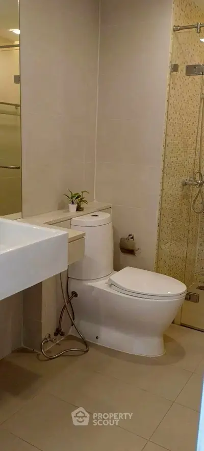Modern bathroom with sleek fixtures and glass shower enclosure.