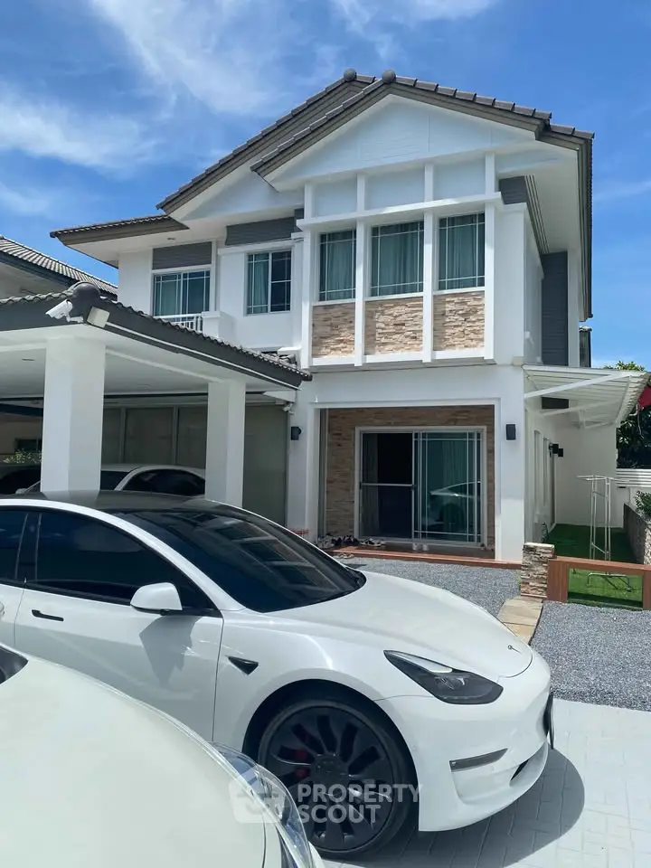 Stunning modern two-story house with sleek design and spacious driveway, perfect for luxury living.