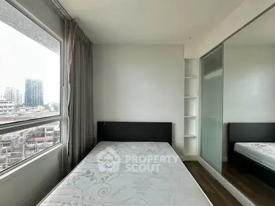 Modern bedroom with city view, featuring a comfortable bed and sleek mirrored wardrobe.