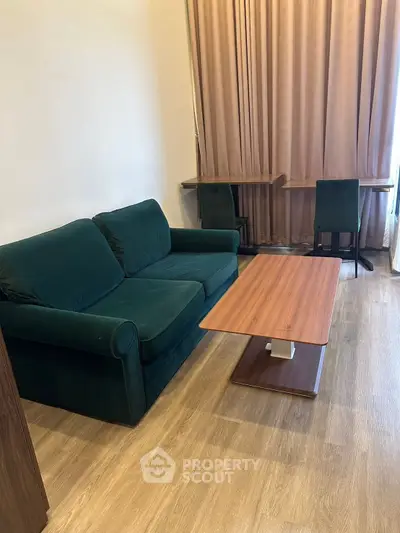 Modern living room with green sofa and wooden coffee table, ideal for cozy gatherings.