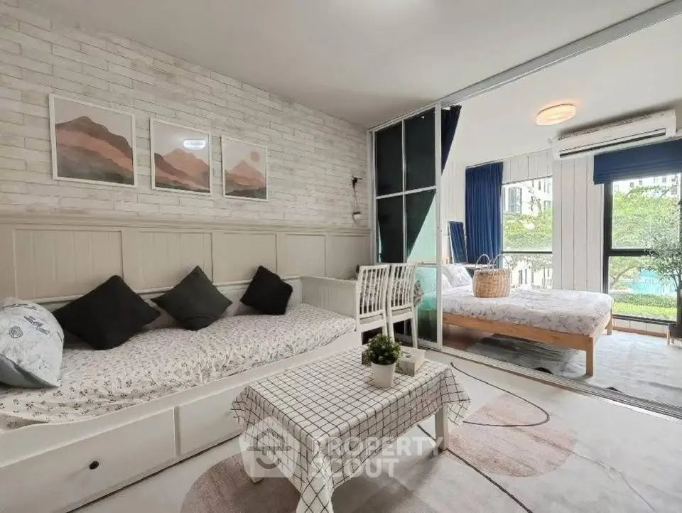 Chic modern living room with cozy bedroom view, stylish decor, and abundant natural light.