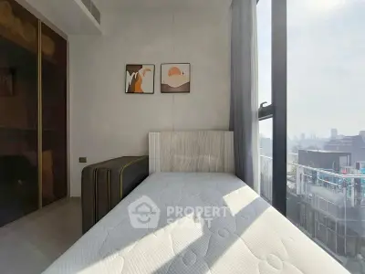 Bright bedroom with modern decor and city view, featuring large windows and stylish artwork.