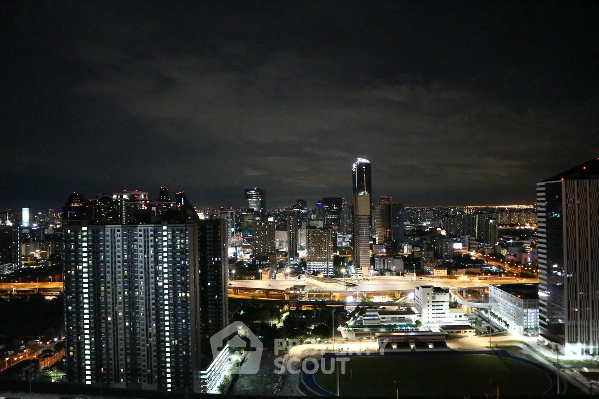 Stunning nighttime cityscape view from a high-rise building, showcasing illuminated skyline and urban landscape.