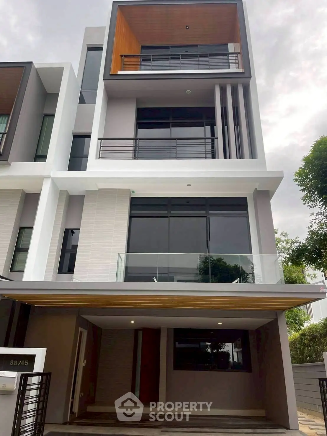 Modern multi-story townhouse with sleek design and large windows in urban setting.