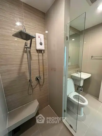 Modern bathroom with glass shower and sleek fixtures in contemporary apartment.