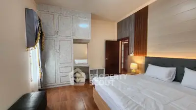 Spacious bedroom with elegant decor and ample natural light, featuring a cozy bed and stylish wardrobe.