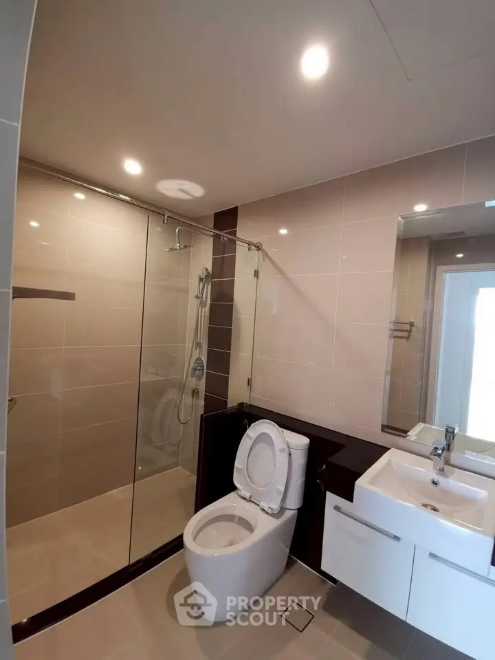 Modern bathroom with glass shower and sleek fixtures in a contemporary home.