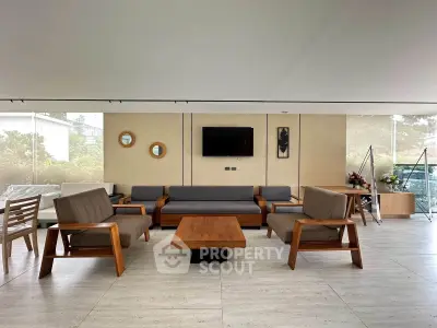 Spacious modern living room with stylish wooden furniture and large windows offering natural light.