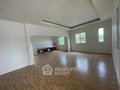 Spacious empty living room with large windows and wooden flooring