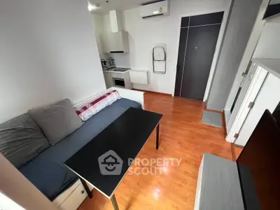 Modern apartment living room with cozy sofa and sleek kitchen area, perfect for urban living.