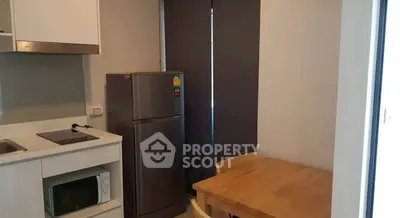 Modern kitchen with sleek appliances and cozy dining area in a compact space.