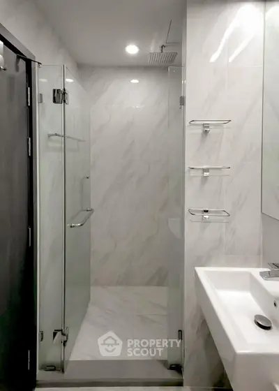 Modern bathroom with glass shower and sleek white sink