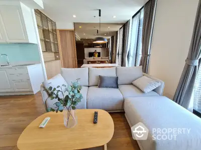 Modern living room with cozy gray sofa, wooden table, and elegant decor in bright natural light.