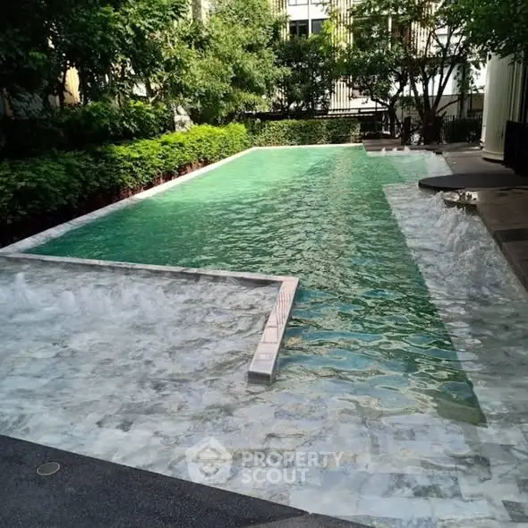 Luxurious residential pool with serene surroundings and lush greenery.