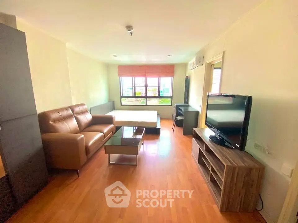 Spacious living room with modern furniture and large window offering natural light.