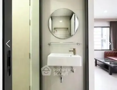 Modern bathroom with round mirror and sleek sink in stylish apartment