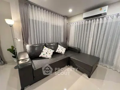 Modern living room with sleek black leather sofa and stylish decor