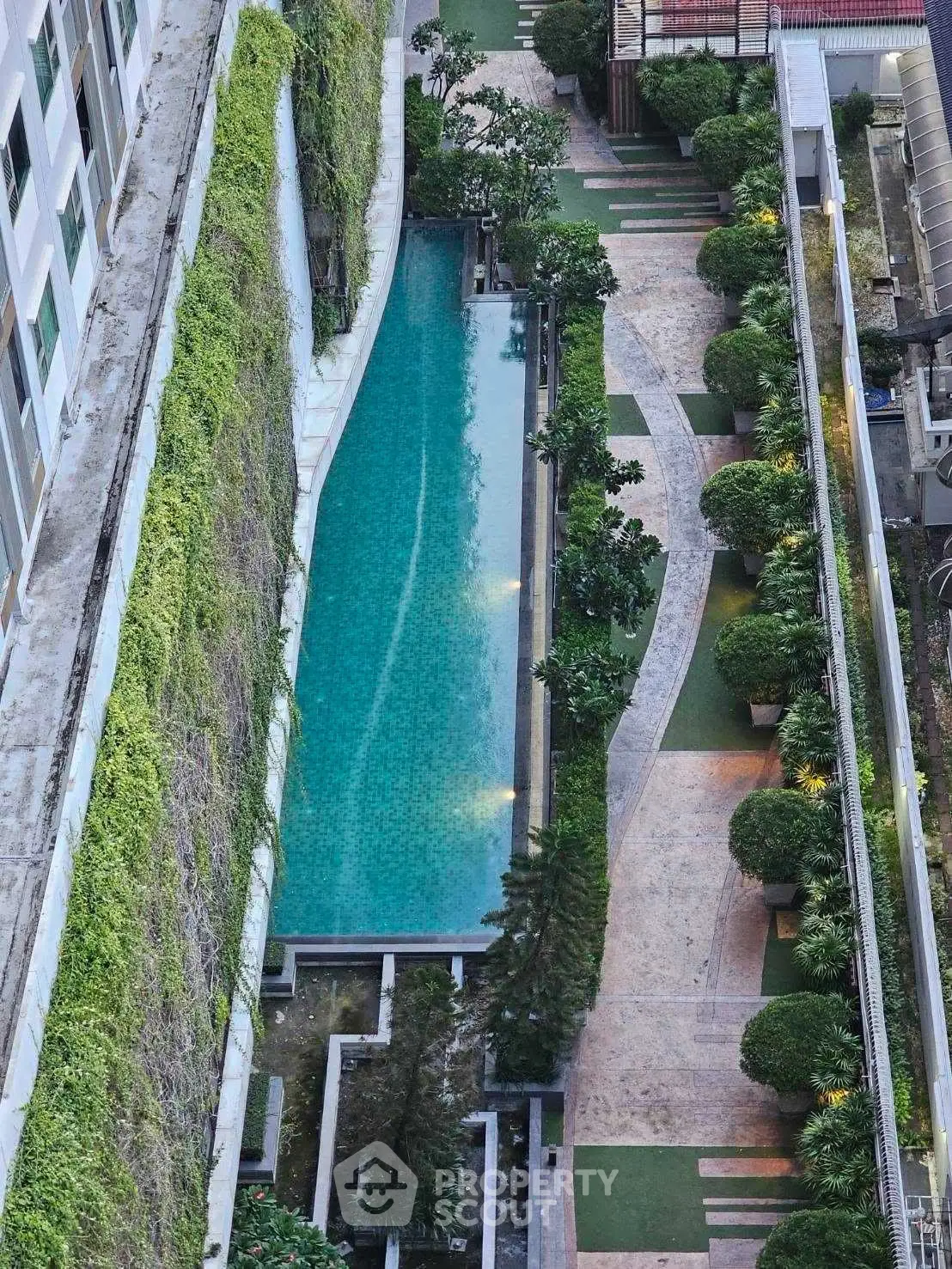Luxurious apartment complex with stunning rooftop pool and lush greenery, offering a serene urban oasis.