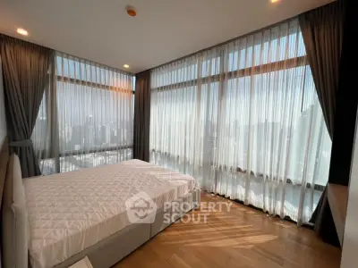 Luxurious bedroom with panoramic city views and elegant floor-to-ceiling windows.