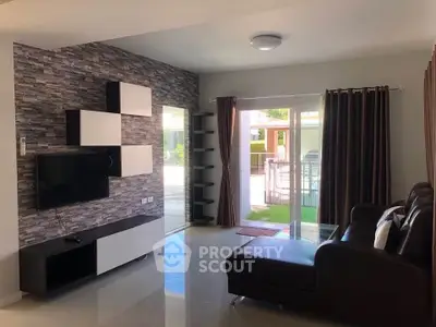 Modern living room with stylish decor and large sliding glass doors opening to a pool view.