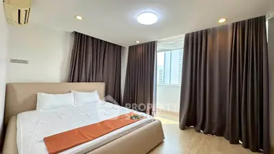 Spacious bedroom with modern design and large windows in a luxury apartment.