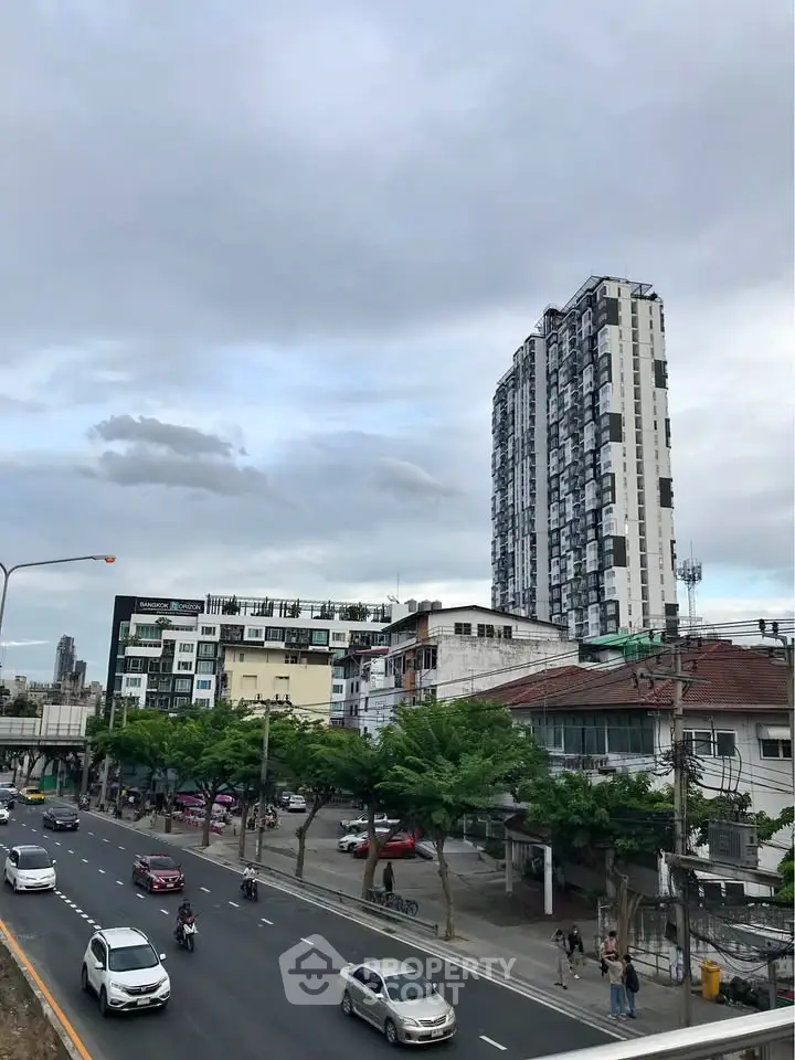 Urban cityscape with modern high-rise building and busy street view.