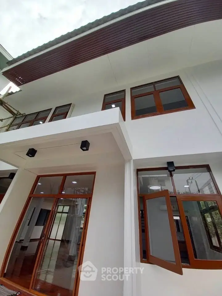 Modern two-story house exterior with large windows and wooden accents