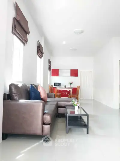 Spacious living room with modern furniture and open kitchen layout, perfect for family gatherings.