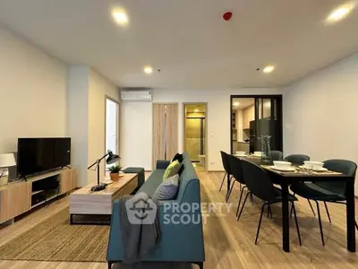 Modern living room with stylish furniture and open dining area in a cozy apartment.