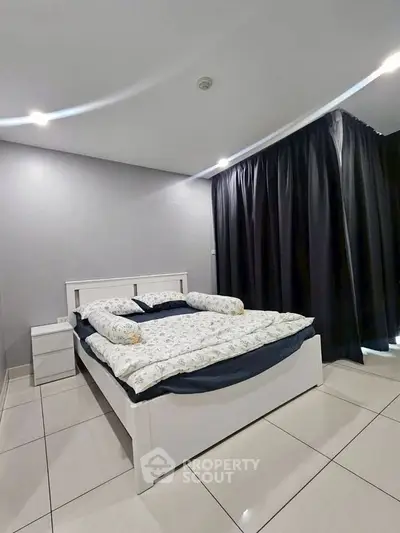 Modern bedroom with sleek design and cozy bedding in a contemporary apartment.