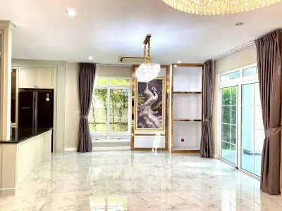 Spacious living room with elegant chandelier and marble flooring in luxury home.