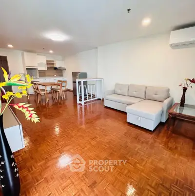 Spacious open-plan living room with modern furniture and wooden flooring.