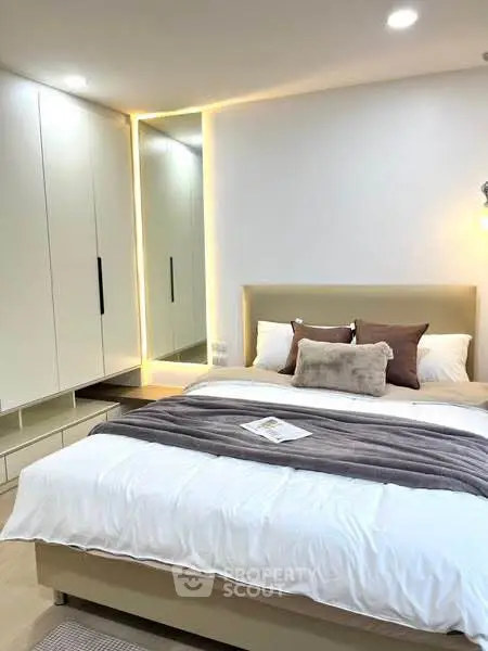 Modern bedroom with stylish decor and built-in wardrobe, perfect for a cozy retreat.