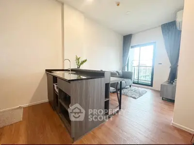 Modern open-plan living room with sleek kitchen island and balcony access, perfect for urban living.
