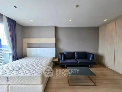 Modern bedroom with sleek design, featuring a comfortable bed and stylish sofa, perfect for urban living.