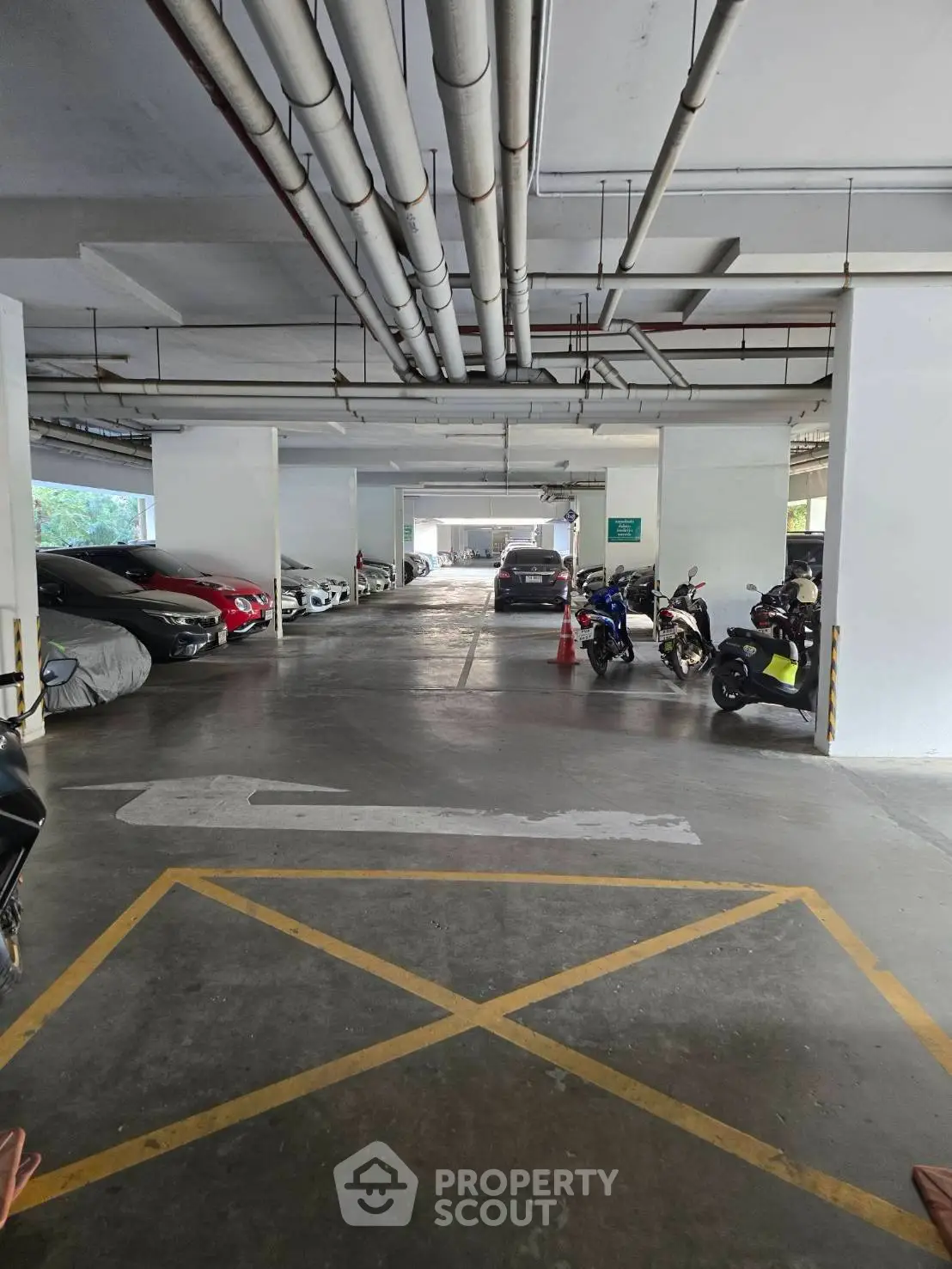 Spacious indoor parking area with ample space for cars and motorcycles, featuring secure and convenient access.