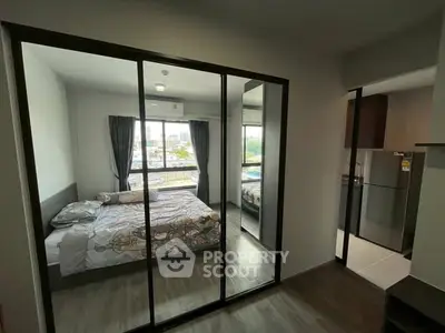Modern bedroom with mirrored closet doors and a view of the city skyline.