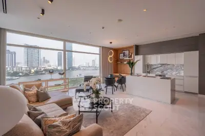 Luxurious open-plan living room with stunning river view and modern kitchen in high-rise apartment.