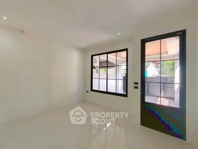 Spacious empty room with large window and glass door, perfect for customization.