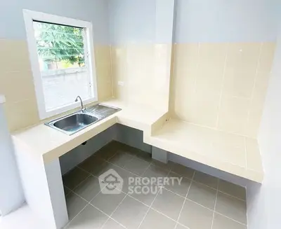Modern kitchen with sleek countertops and large window for natural light.