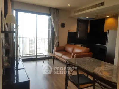 Modern living room with balcony view, featuring stylish furniture and open layout.