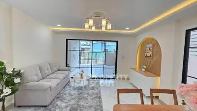 Modern living room with elegant decor and spacious layout, featuring a cozy sofa and stylish lighting.