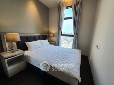 Modern bedroom with city view, featuring elegant decor and natural light.