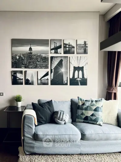Stylish living room with modern decor and cityscape wall art, featuring a cozy gray sofa and geometric cushions.