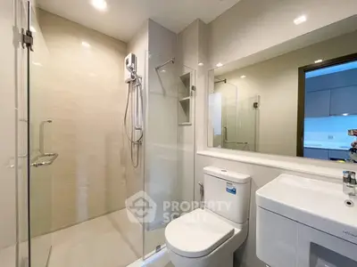 Modern bathroom with glass shower and sleek fixtures in a contemporary apartment.