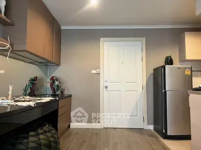Modern kitchen with sleek cabinets and stainless steel fridge in cozy apartment